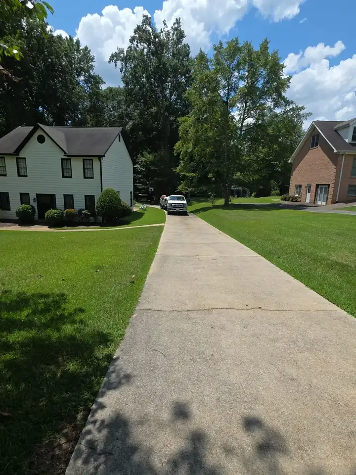 Long concrete driveway leading to a two-story home at a pressure washing job in Canton, GA.