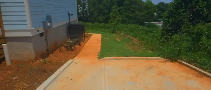 Concrete side path running alongside a new construction home at a pressure washing job in Atlanta, GA.