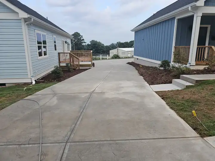 Concrete driveway between two newly constructed homes after pressure washing at a new construction job in Atlanta, GA.