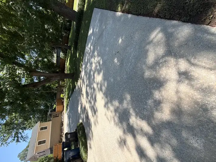 Wide concrete driveway pad freshly pressure washed and clean in the sun in East Point, GA