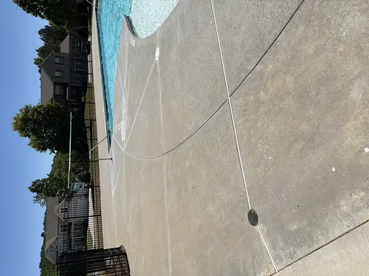 Pressure-washed concrete pool deck beside kidney-shaped community pool in Canton, GA, clean result