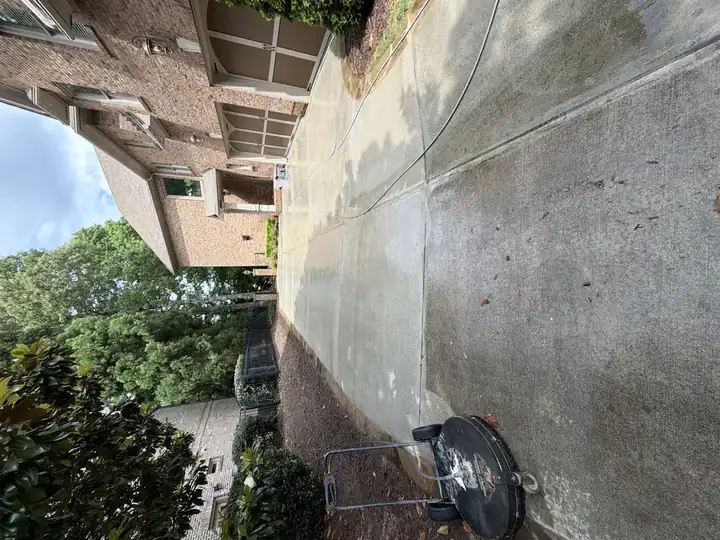 Concrete driveway being cleaned with a rotary surface cleaner during a pressure washing job at a Duluth, GA home.