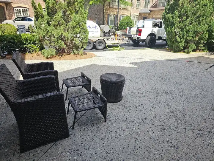 Alpha Pressure Washing truck and tank trailer staged on an exposed aggregate driveway during a job in Marietta, GA.