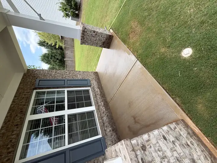 Concrete front porch with heavy rust and mildew staining before pressure washing service in Canton, GA