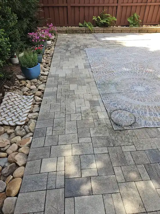 Stone paver path with visible grime and organic buildup beside an outdoor rug at a Marietta, GA home.