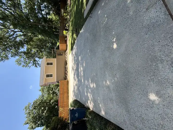 Rear concrete driveway pressure washed clean with open blue sky in East Point, GA