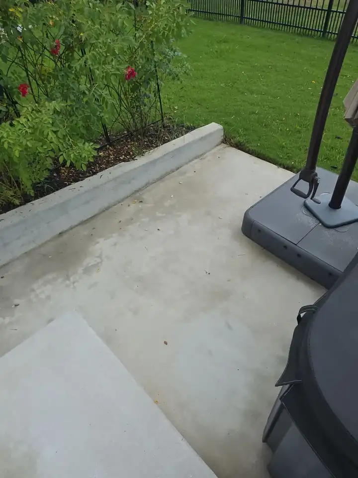 Close-up of a concrete patio surface and edge border beside a garden bed at a pressure washing job in Canton, GA.