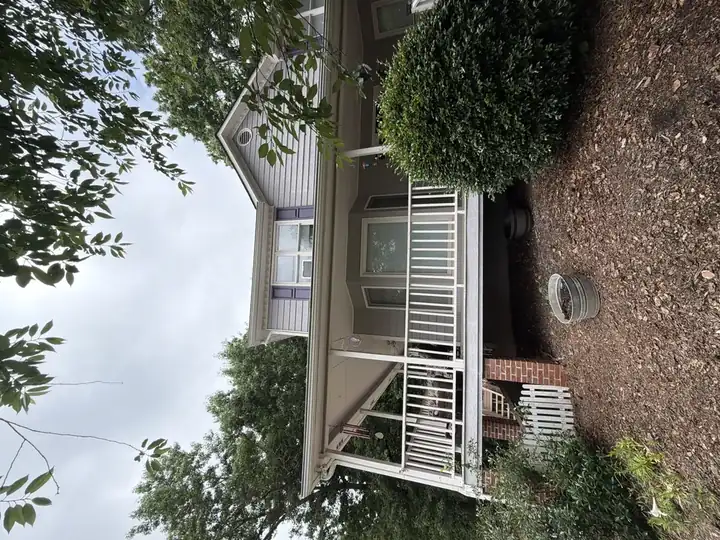 Rear exterior of two-story Canton, GA home showing clean vinyl siding and covered porch after house washing service