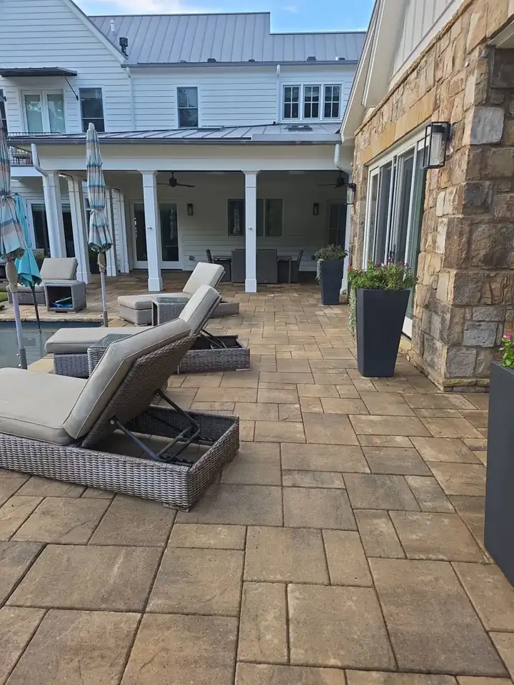 Stamped concrete pool patio with chaise lounges beside a residential pool at a pressure washing job in Milton, GA.