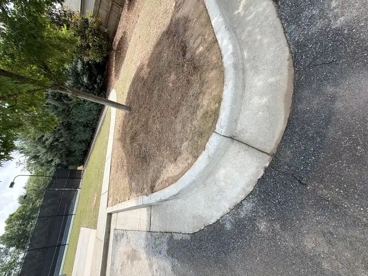 Clean concrete curb and parking island after pressure washing at a commercial property in Canton, GA