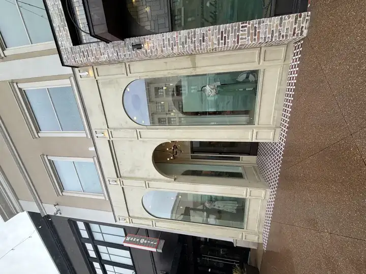 Wide after shot of pressure-washed stucco commercial building facade with two arched windows and entrance in Alpharetta, GA