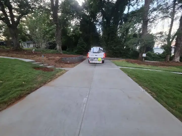 Concrete driveway at dusk with pressure washing truck departing after a new construction wash job in Atlanta, GA.