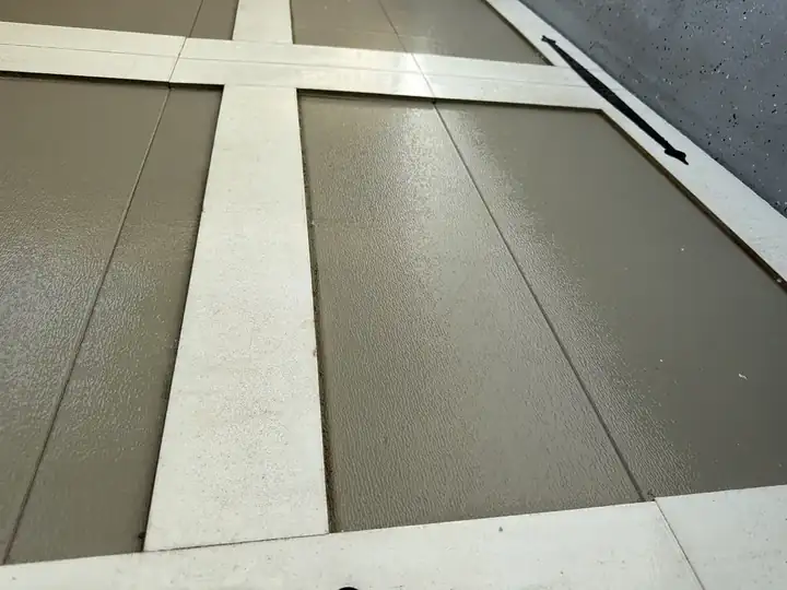 Yellow-green sheen on the paintwork of the garage door.