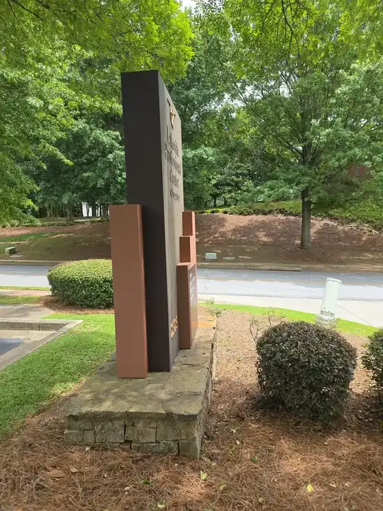 Side-angle view of a commercial monument sign on a stone base after soft washing in Duluth, GA.